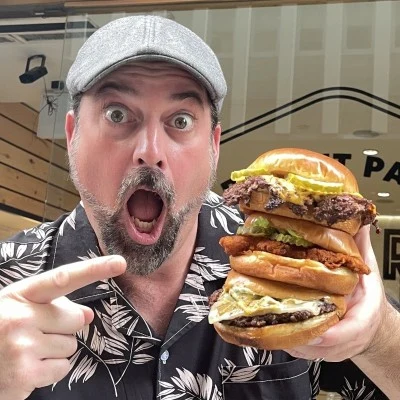 Rev Ciancio holding a stack of burgers
